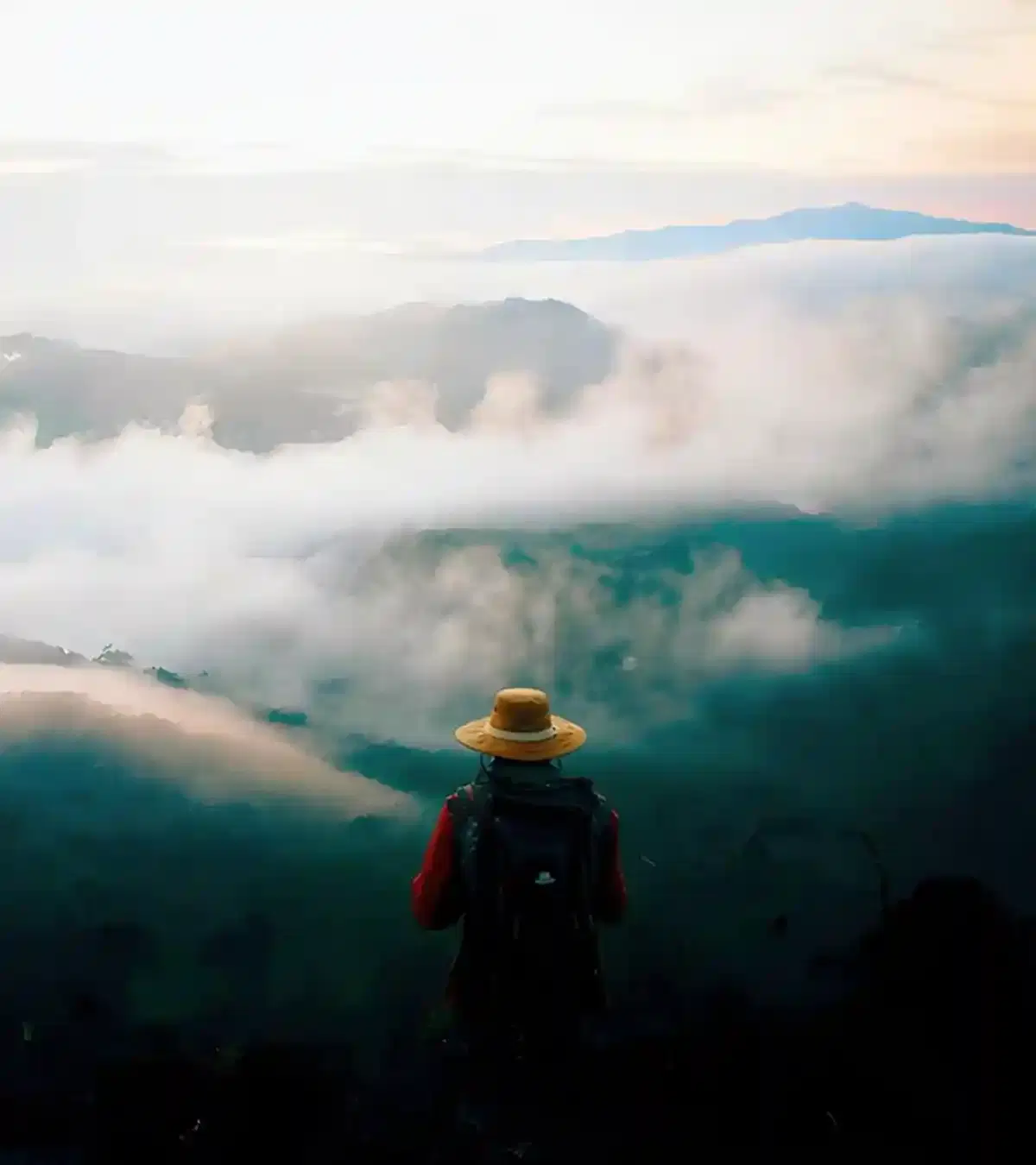 Mountain background with a single hiker in the foreground looking out at the view